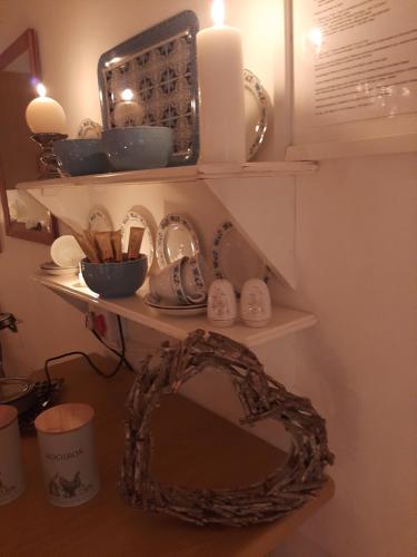 a mirror and a shelf with dishes and a candle at Rosenhof Studio Five - When Privacy is Important in Clanwilliam