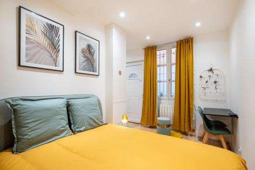 a bedroom with a yellow bed and a desk at Le Cocon De Paris in Lyon