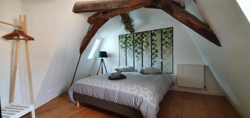 a bedroom with a bed in a attic at Appartement Duplex au Coeur du Centre Historique in Bergerac