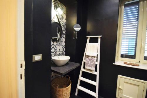 uma casa de banho preta com um lavatório e uma escada em La Casetta em Palermo