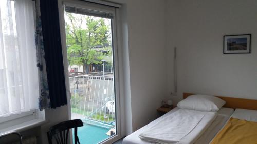 a room with a bed and a window with a balcony at Haus Edith Privathaus mit Gästezimmern in Bregenz