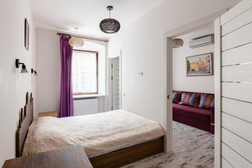 sypialnia z łóżkiem i fioletową kanapą w obiekcie Lion King Krakivska w Lwowie