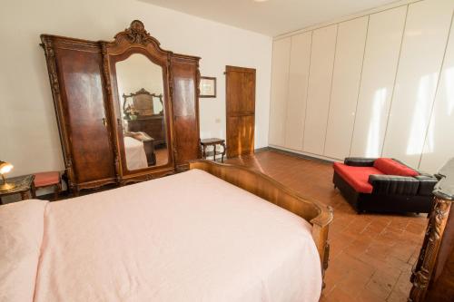 a bedroom with a bed and a mirror and a couch at Podere Magnolia in Pisa