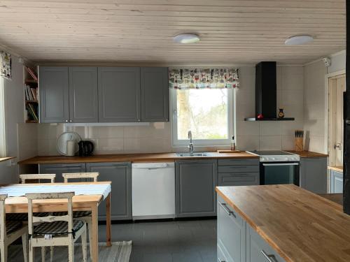 a kitchen with gray cabinets and a wooden table at Stora Ulvebo in Söderköping