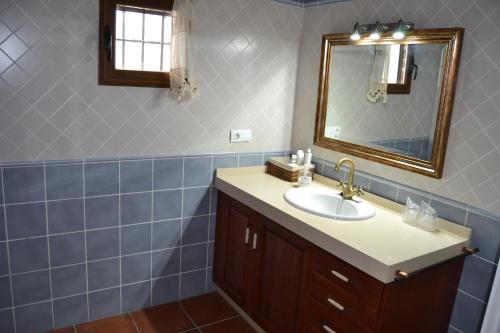un bagno con lavandino e specchio di Casa Rural Los Jarales Número Registro TR-CC-00365 a Casar de Cáceres