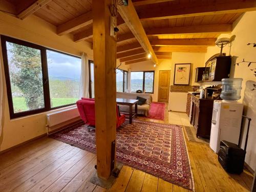 a living room with a table and some windows at Cozy cottage in countryside close to Tbilisi in Dushetʼi