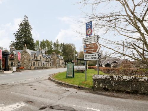 a street sign with directional signs on the side of a road at Verdi in Pitlochry