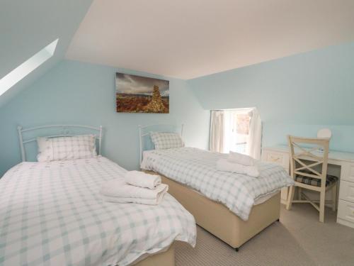 1 dormitorio con 2 camas y ventana en Puccini en Pitlochry