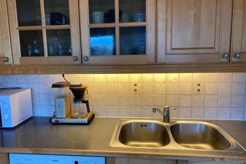 a kitchen counter with a sink and a coffee maker at Marikollen, spacious appartment with sunny veranda in Kristiansand