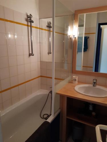 une salle de bain avec une baignoire, un lavabo et un miroir dans l'établissement Proche des Sables D'Olonne appartement calme pour 4 personnes situé face au Golf de Bourgenay à Talmont st Hilaire, à Talmont-Saint-Hilaire