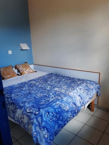 une chambre avec un lit avec une couette bleue dans l'établissement Proche des Sables D'Olonne appartement calme pour 4 personnes situé face au Golf de Bourgenay à Talmont st Hilaire, à Talmont-Saint-Hilaire