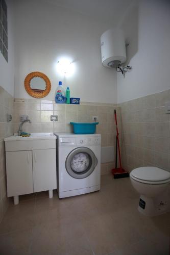 a bathroom with a washing machine and a toilet at Villa Cecita in Sellia Marina