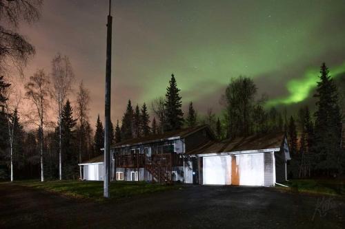 an old building with the aurora in the sky at Peaceful Nature Escape with Deck in North Pole! in North Pole