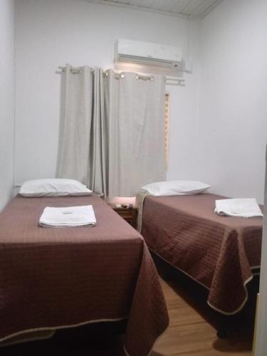 a room with two beds and a window at Pousada Da Campanha in Bagé