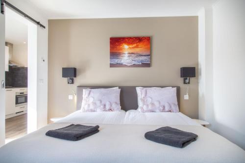 een slaapkamer met een bed met twee handdoeken erop bij Vrijstaande vakantiewoning Petite Renard in Zoutelande