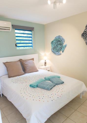 a bedroom with a white bed with two pillows on it at Kaz O'Rocher - Sea View Appartements in Le Diamant