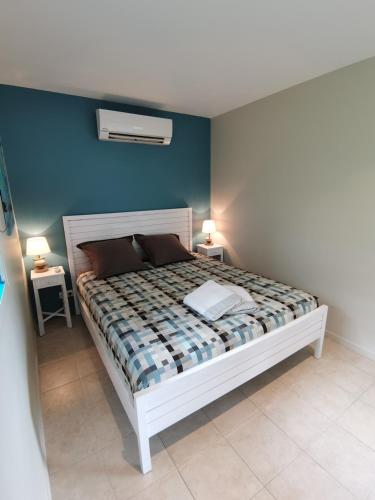a bedroom with a bed with two tables and two lamps at Kaz O'Rocher - Sea View Appartements in Le Diamant