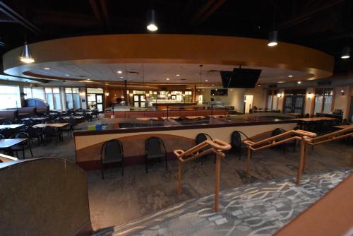 a restaurant with tables and chairs and a bar at Canad Inns Destination Centre Polo Park in Winnipeg