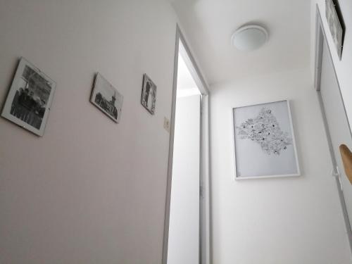 a hallway with a mirror and pictures on a wall at La Maison des Rosiers in Manhac