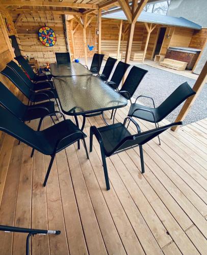 a group of chairs and a table on a deck at UBYTOVÁNÍ S WELLNESS in Dolní Dobrouč