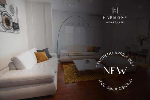 a living room with a white couch and a table at Harmony Apartmani Arandjelovac in Arandjelovac