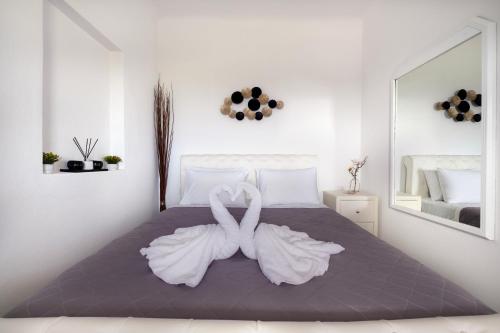 una camera con un letto con due cigni bianchi di Blue Soul Luxury Villa a Éxo Goniá