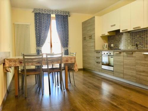 a kitchen with a table and chairs in a room at Appartamenti Sissi in Commezzadura
