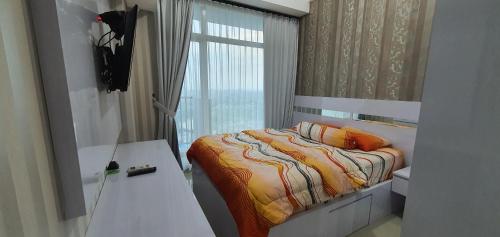 a small bedroom with a bed and a window at TreeParkCity apartments by WinsHome in Tangerang