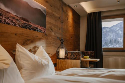 una camera con un letto e una parete in legno di loisi's Boutiquehotel ad Achenkirch
