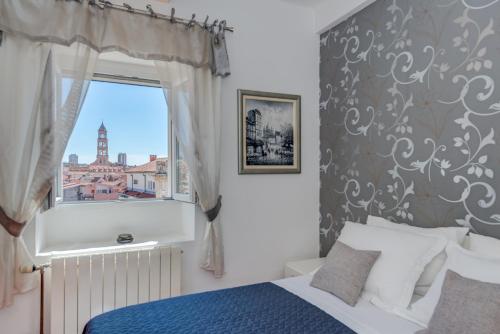 斯普利特Marmont Suite的一间卧室，里面有一张床和一扇窗户。