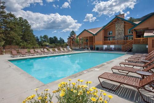 a swimming pool with lounge chairs and a house at WorldMark Estes Park in Estes Park