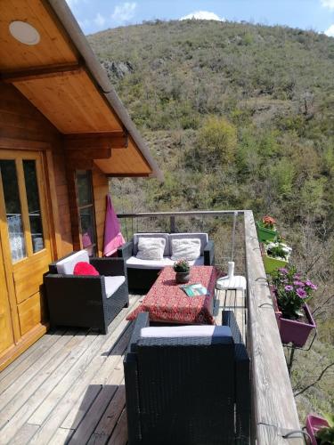 a deck with couches and a table on a house at Chalet sur pilotis avec piscine privée in Lucéram