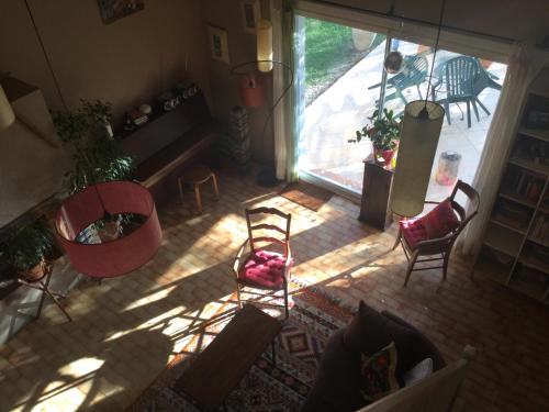 - une vue de tête sur un salon avec des chaises et une fenêtre dans l'établissement Joli Mas au bord de l'Etang de Thau, à Marseillan