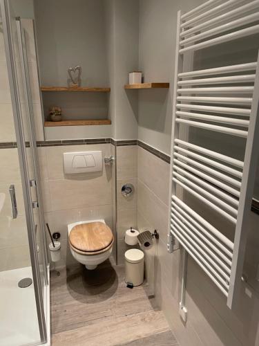 a small bathroom with a toilet with a wooden seat at Strandnest in Wyk auf Föhr