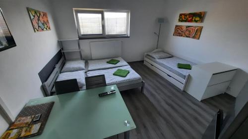a small room with two beds and a table at Penzion u vody in Plzeň