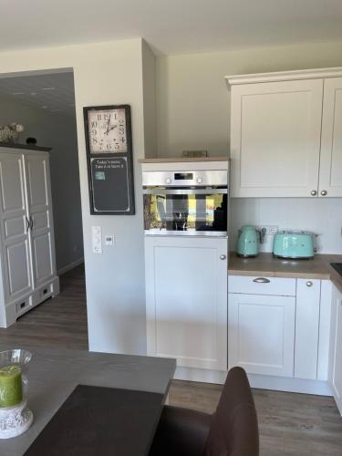 a kitchen with white cabinets and a white oven at Strandnest in Wyk auf Föhr