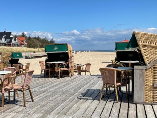 a wooden deck with tables and chairs on the beach at Strandnest in Wyk auf Föhr