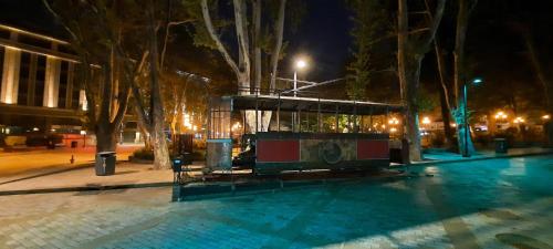 a swimming pool in a city at night at center LG Apartment in Tbilisi City