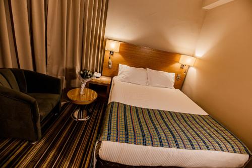 um quarto de hotel com uma cama e uma cadeira em Mustafa Cappadocia Resort em Ürgüp
