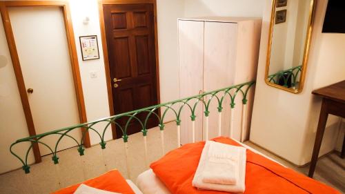 a bedroom with a mirror and a bed with orange sheets at Hotel Soazza in Soazza