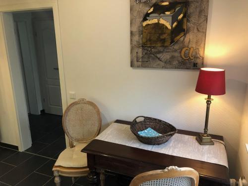 a room with a table with a lamp and two chairs at Lykkehus in Humptrup