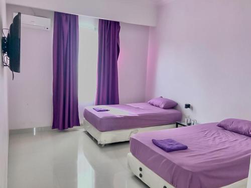 Tiara Guest House Mitra RedDoorz tesisinde bir odada yatak veya yataklar