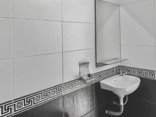 een badkamer met een wastafel en een spiegel bij Tiara Guest House Mitra RedDoorz in Samarinda
