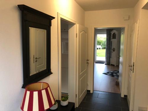 a hallway with a chair and a mirror on the wall at Lykkehus in Humptrup