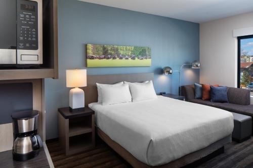a hotel room with a bed and a couch at Hyatt House Tallahassee Capitol University in Tallahassee