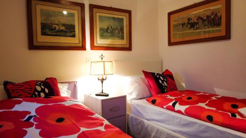 a bedroom with two beds and a lamp and pictures at Hotel Soazza in Soazza
