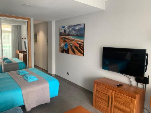 1 dormitorio con 1 cama y TV de pantalla plana en Marsin Playa 408 Vivienda vacacional, en Las Palmas de Gran Canaria