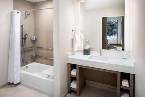 a bathroom with a sink and a tub and a toilet at Hyatt House Tallahassee Capitol University in Tallahassee