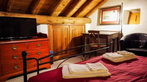 a bedroom with a bed with a flat screen tv at Hotel Soazza in Soazza