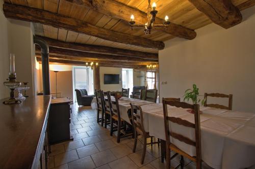 uma sala de jantar com uma mesa longa e cadeiras em Gîtes du Chênelong Cantal em Marchastel
